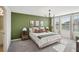 Comfortable bedroom showcasing a green accent wall, soft lighting and large windows at 734 Longboat Dr, Davenport, FL 33896