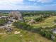 Aerial view of resort near a golf course and lush greenery, surrounded by trees and sand traps at 7509 Mourning Dove Cir # 203, Reunion, FL 34747