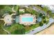 Aerial view of a community pool and recreation area, complete with lush landscaping and a fountain at 7509 Mourning Dove Cir # 203, Reunion, FL 34747
