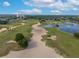 An aerial view of a sprawling golf course with sand traps, water features, and manicured greens at 7509 Mourning Dove Cir # 203, Reunion, FL 34747