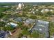 An aerial view showcases tennis courts and a pool amidst lush greenery and mature trees at 7509 Mourning Dove Cir # 203, Reunion, FL 34747