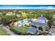 Overhead view of community pool, golf course, and bocce court amid manicured greenery at 7509 Mourning Dove Cir # 203, Reunion, FL 34747