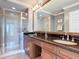 Well-appointed bathroom with double sinks, granite counters, and a tiled shower at 7509 Mourning Dove Cir # 203, Reunion, FL 34747