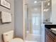 Bathroom with a tiled walk-in shower, toilet, and granite countertop vanity at 7509 Mourning Dove Cir # 203, Reunion, FL 34747