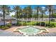 Beautiful fountain view with palm trees, white columns, manicured lawn, and nearby building on a clear sunny day at 7509 Mourning Dove Cir # 203, Reunion, FL 34747