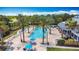 An elevated view shows a community pool lined with palm trees, plus ample seating and shade at 7509 Mourning Dove Cir # 203, Reunion, FL 34747