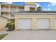 Two-car garage with white doors complementing the building's exterior at 7509 Mourning Dove Cir # 203, Reunion, FL 34747