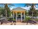Elegant community gazebo with seating, mature trees, and nearby lounge chairs at 7509 Mourning Dove Cir # 203, Reunion, FL 34747