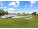 Scenic golf course view featuring a bridge over a lake and lush green fairways at 7509 Mourning Dove Cir # 203, Reunion, FL 34747
