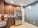 Kitchen with stainless steel appliances, dark wood cabinetry and granite countertops at 7509 Mourning Dove Cir # 203, Reunion, FL 34747
