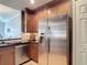 Kitchen with stainless steel refrigerator, dark wood cabinets, and granite countertop at 7509 Mourning Dove Cir # 203, Reunion, FL 34747