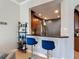 Kitchen pass through to bar with barstool seating and shelving at 7509 Mourning Dove Cir # 203, Reunion, FL 34747