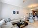 Spacious living area with sectional sofa and view into the kitchen at 7509 Mourning Dove Cir # 203, Reunion, FL 34747