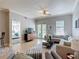 Bright living room with neutral tones, tile floors, balcony access and a peek into the primary bedroom at 7509 Mourning Dove Cir # 203, Reunion, FL 34747