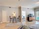 Living room featuring tile floors, table and chairs, and a glimpse into the cozy primary bedroom at 7509 Mourning Dove Cir # 203, Reunion, FL 34747