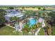 Aerial view of a large community pool with palm trees and surrounding amenities at 7509 Mourning Dove Cir # 203, Reunion, FL 34747