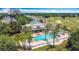 Aerial view of a community pool, golf course, and lush landscaping at 7509 Mourning Dove Cir # 203, Reunion, FL 34747