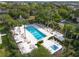 Aerial view of a beautiful pool and spa area surrounded by lounge chairs and greenery at 7509 Mourning Dove Cir # 203, Reunion, FL 34747