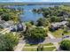 Stunning aerial view of the home, surrounded by mature trees, on a gorgeous lake at 7540 Lake Marsha Dr, Orlando, FL 32819