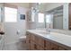 Bathroom featuring a functional vanity, bright mirror and patterned wallpaper at 7540 Lake Marsha Dr, Orlando, FL 32819