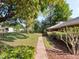 Well-maintained front yard featuring a lush lawn, mature trees, and a charming walkway leading to the home at 7540 Lake Marsha Dr, Orlando, FL 32819