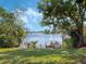 Picturesque lake view showcasing a private wooden dock and lush green lawn, perfect for relaxing by the water at 7540 Lake Marsha Dr, Orlando, FL 32819