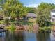 Beautiful lake view with private dock, lush landscaping, and a glimpse of the home's exterior at 7540 Lake Marsha Dr, Orlando, FL 32819
