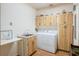 Laundry room featuring a washer, dryer, sink, overhead storage and tiled floors at 7540 Lake Marsha Dr, Orlando, FL 32819