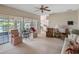 Spacious living room with a ceiling fan, large windows, and a seamless transition to the kitchen at 7540 Lake Marsha Dr, Orlando, FL 32819