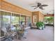 Enclosed brick patio featuring a ceiling fan, table, chairs, and view of the yard at 7540 Lake Marsha Dr, Orlando, FL 32819