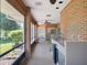Enclosed brick patio featuring a ceiling fan, table, chairs, and outdoor kitchen area at 7540 Lake Marsha Dr, Orlando, FL 32819