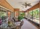 Enclosed brick patio featuring a ceiling fan, table, chairs, and view of the yard at 7540 Lake Marsha Dr, Orlando, FL 32819