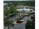 Panoramic aerial view of a landscaped community featuring a picturesque pond with a fountain and parking areas at 8101 Resort Village Dr # 3909, Orlando, FL 32821