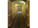 Long hallway with patterned carpets and warm, inviting lighting at 8101 Resort Village Dr # 3909, Orlando, FL 32821
