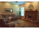 Cozy living room featuring a brick fireplace, plush seating, and lots of natural light at 859 Morning Star Dr, Lakeland, FL 33810