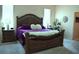 Luxurious main bedroom with a large, decorative wood bed frame, and two side tables at 859 Morning Star Dr, Lakeland, FL 33810
