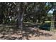 Beautiful wooded lot with large trees and green bench swing at 859 Morning Star Dr, Lakeland, FL 33810
