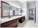 Bathroom features dual sinks, granite countertops, a large mirror, and a doorway leading to the bedroom at 903 Kersfield Cir, Lake Mary, FL 32746