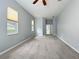 Large bedroom with carpeted floor, ceiling fan, and several windows offering natural light at 903 Kersfield Cir, Lake Mary, FL 32746