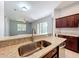 Kitchen with granite countertops, a stainless steel sink, and dark wood cabinetry overlooking the living area at 903 Kersfield Cir, Lake Mary, FL 32746