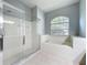 Bright bathroom featuring a glass-enclosed shower and soaking tub, offering a spa-like experience at 903 Kersfield Cir, Lake Mary, FL 32746