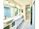 Bathroom featuring double sinks with white cabinets and black and white patterned tile flooring at 9490 Sw 85Th Ave # E, Ocala, FL 34481