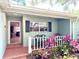 Charming covered front porch with brick detail, a small garden, and seating area at 9490 Sw 85Th Ave # E, Ocala, FL 34481