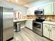 Bright kitchen with stainless steel appliances, light cabinets, and stylish backsplash, adjacent to the living area at 9490 Sw 85Th Ave # E, Ocala, FL 34481