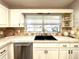 Bright kitchen with white cabinets, neutral countertops, stainless steel dishwasher, and a double basin sink at 9490 Sw 85Th Ave # E, Ocala, FL 34481