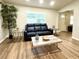 Cozy living room with natural light, laminate flooring, and comfortable seating arrangement at 9490 Sw 85Th Ave # E, Ocala, FL 34481