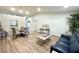 Open-concept living area showcasing laminate flooring, vaulted ceilings and comfortable seating at 9490 Sw 85Th Ave # E, Ocala, FL 34481