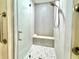 Modern bathroom featuring an updated shower with stone bench, gray tile, and glass door at 9490 Sw 85Th Ave # E, Ocala, FL 34481