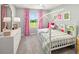 Charming bedroom with pink floral curtains, stylish decor, and a house-frame bed with built-in bookshelves at 9964 Red Canoe Aly, Orlando, FL 32832