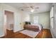 Comfortable bedroom with hardwood floors, soft rug, neutral color scheme, and ample light from a ceiling fan at 1000 Pennsylvania Ave, Lakeland, FL 33803